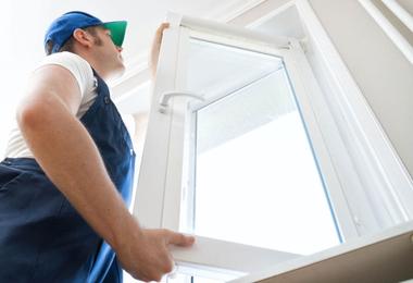Window installer installing a replacement window in Canada