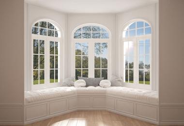 Minimalist home interior with a large bay or bow window overlooking a garden meadow panorama