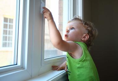 Child using a window with a safety lock in a Canadian home