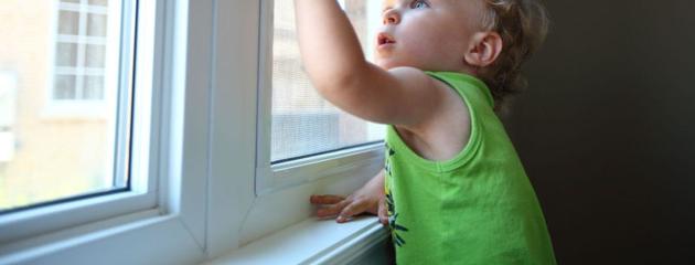 Child using a window with a safety lock in a Canadian home