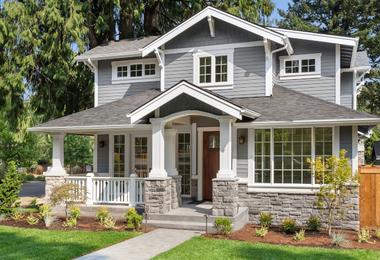 Craftsman-style home exterior with large energy-efficient windows on a sunny day