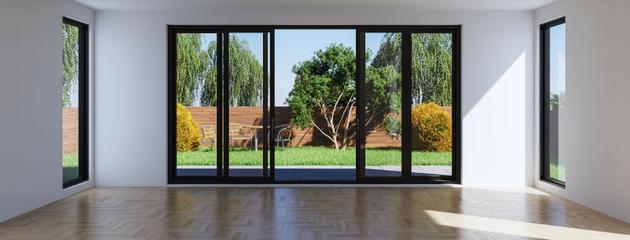 Modern living room with folding patio glass doors connecting the indoor space to the outdoor patio.