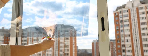 Residential glass window showing the effect of safety film on light transmission and privacy while illustrating glass protection features.