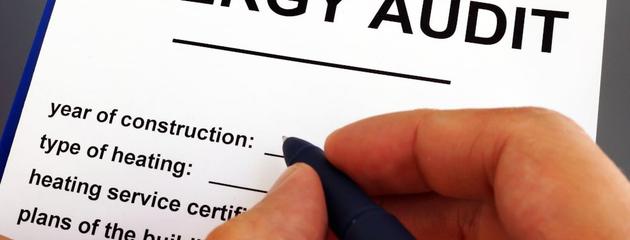 Home energy auditor completing an inspection form during a residential energy efficiency assessment.