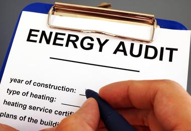 Home energy auditor completing an inspection form during a residential energy efficiency assessment.