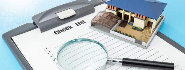 House model with a clipboard checklist, representing a comprehensive home inspection for Canadian homebuyers.