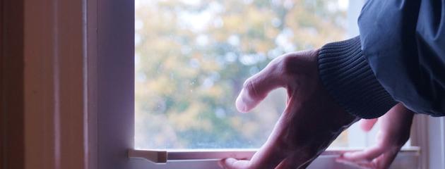 Hand holding a window pane, showing the edge where spacers are located