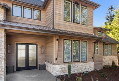 Beautiful, large, luxury suburban home exterior with modern windows, landscaped yard, and high-end residential design