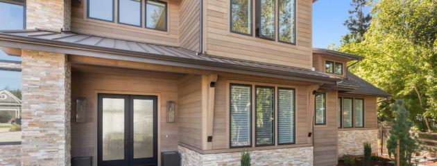 Beautiful, large, luxury suburban home exterior with modern windows, landscaped yard, and high-end residential design