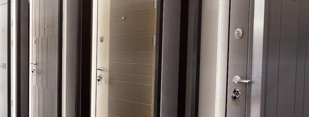 Modern entry doors displayed in a showroom, showing steel, fibreglass, and wood options for Canadian homes.