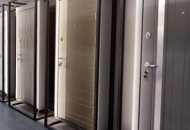 Modern entry doors displayed in a showroom, showing steel, fibreglass, and wood options for Canadian homes.