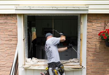 Homeowner reviewing replacement window options for energy-efficient windows in Canada.