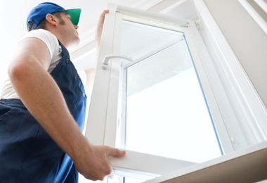 A professional installing a replacement window in a Calgary home, showing the window replacement cost context