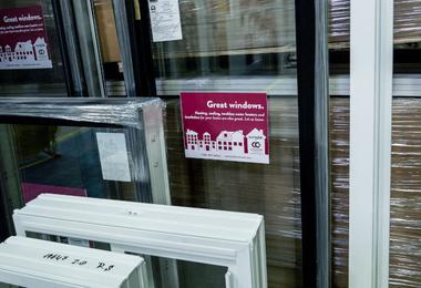 Stacked vinyl window units in a warehouse ready for installation