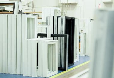 Vinyl window frames in a manufacturing facility showing different sizes and designs before installation