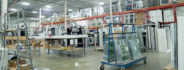 Window manufacturing warehouse with glass units and frames organized on racks