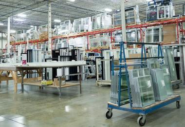 Window manufacturing warehouse with glass units and frames organized on racks