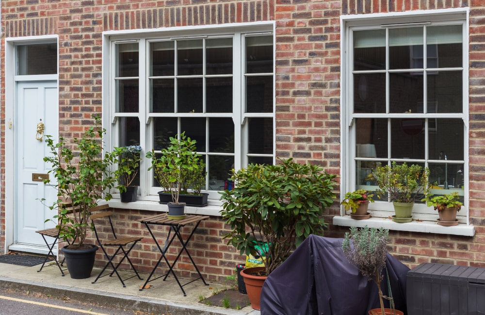 Traditional sliding sash cottage-style windows on a brick London townhouse showing 40/60 sash proportions and heritage detailing.