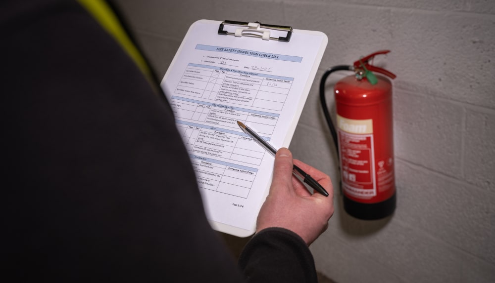 Clipboard with fire safety checklist, representing smoke detector and carbon monoxide detector inspection during a home evaluation.