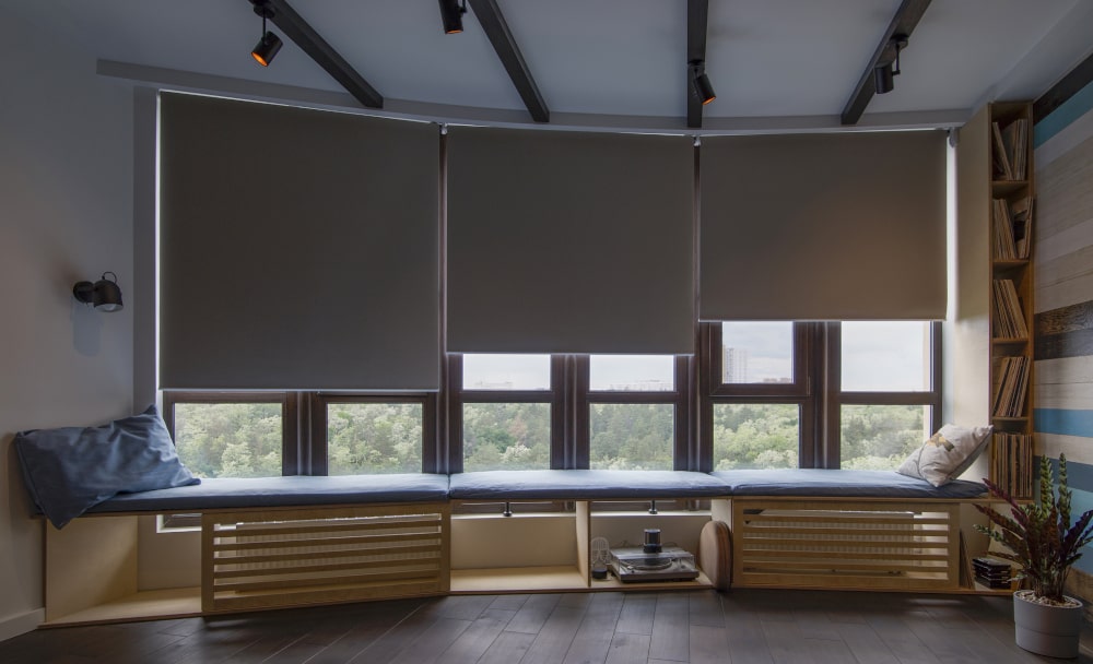 Roller blinds in the interior for tall high-ceiling windows