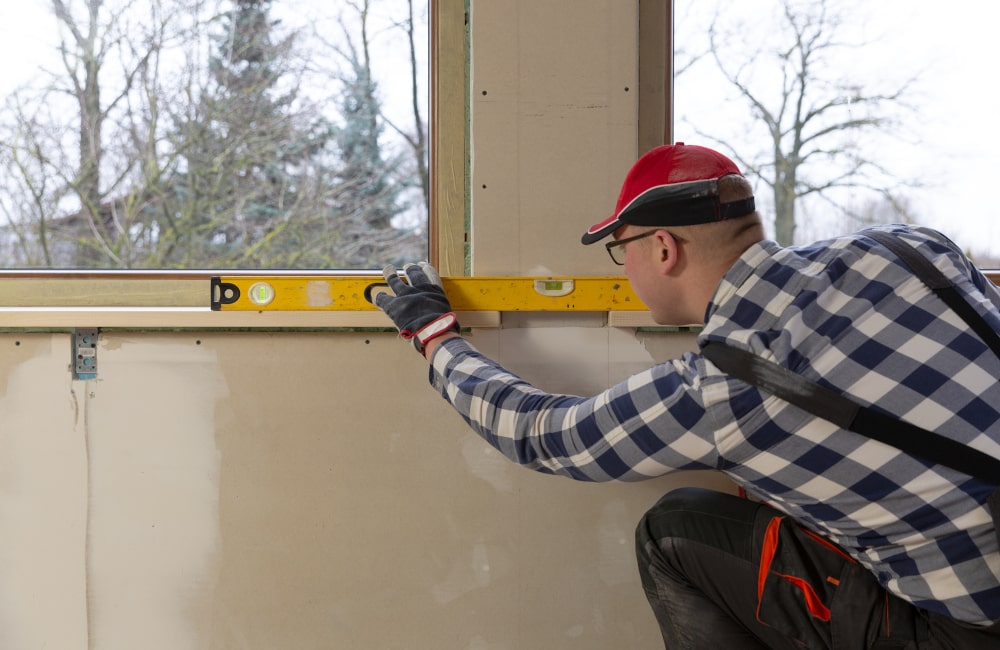 Applying exterior caulk and finish to seal a newly installed exterior window sill