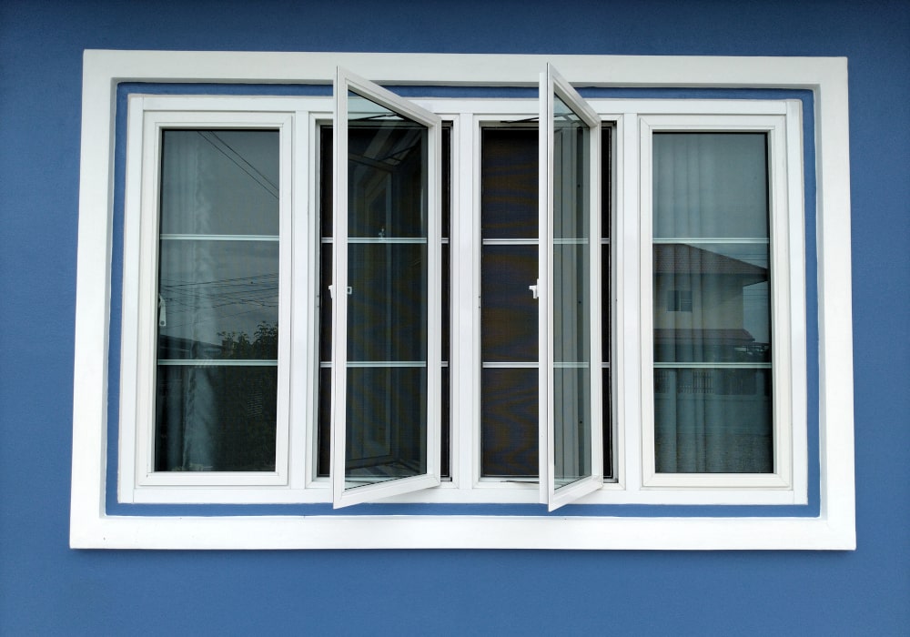 White casement window on a Canadian home with blue accent wall, modern design
