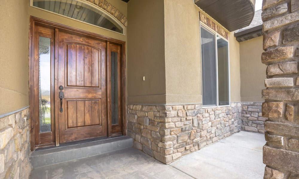 Wood front door with sidelights showing classic styling and warm, natural finish