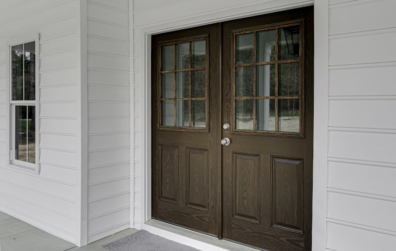 Brown double wooden entry doors with glass panels
