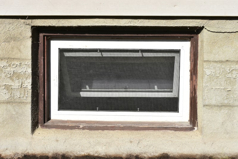 A small, outdated basement window not suitable for legal egress in older Canadian homes
