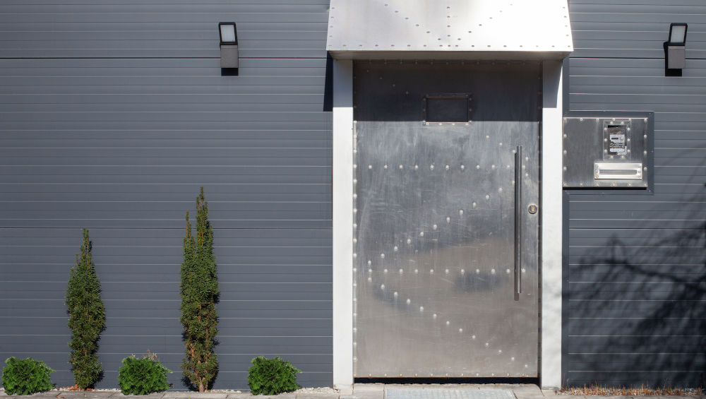 Reinforced metal entry door illustrating how dents, corrosion, and hardware wear can affect door security and long-term performance.