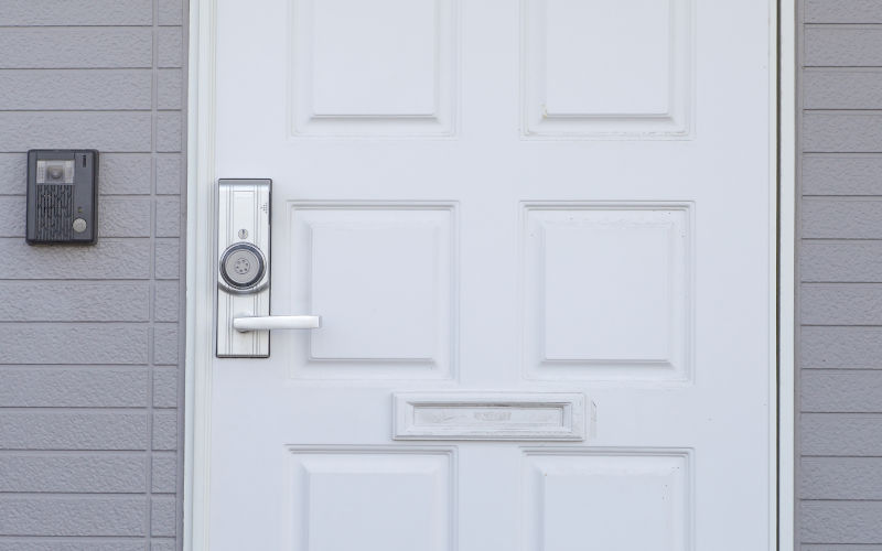 White entry door against a brick wall in a Canadian home, showing a typical door setup used when measuring the door backset.