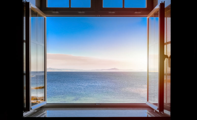 Open window overlooking the sea, highlighting coastal conditions and the need for high-wind resistant window features