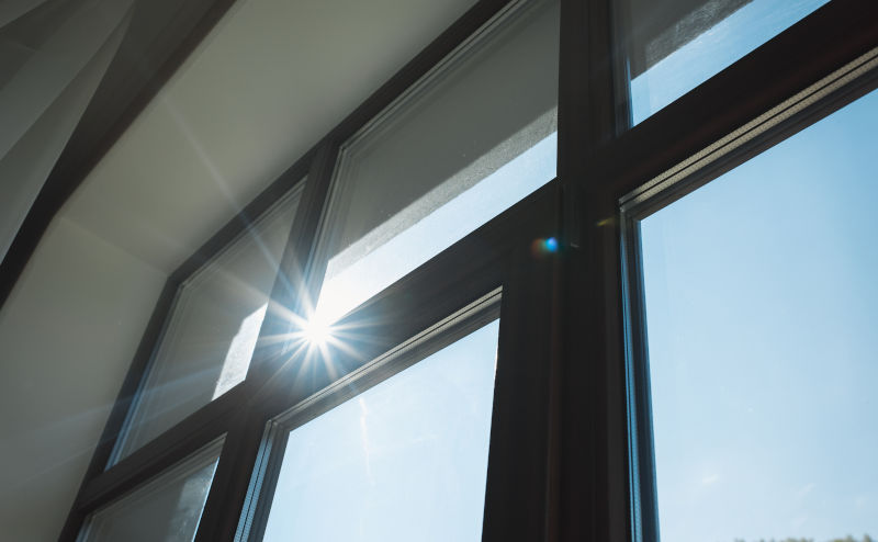 Morning sunlight streaming through large modern windows in a suburban home, illustrating natural light optimization in interior design