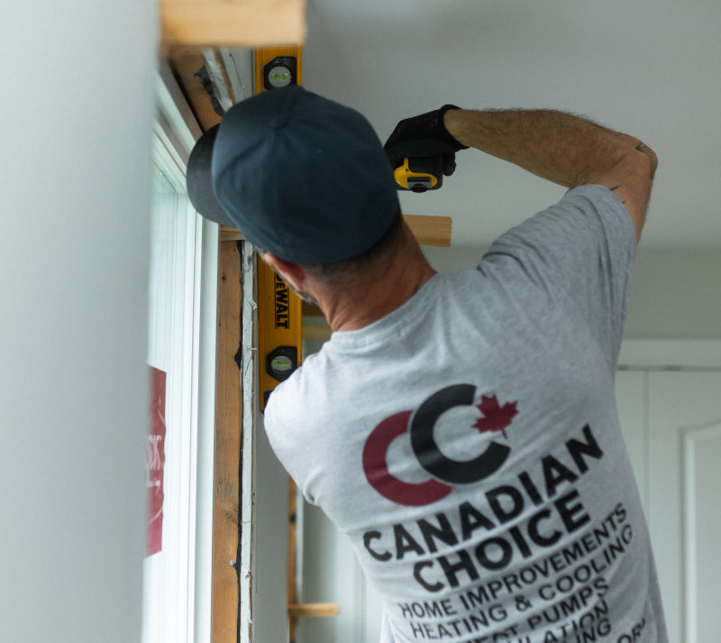 A professional installing a replacement window, ensuring proper sealing and alignment in a Canadian home.