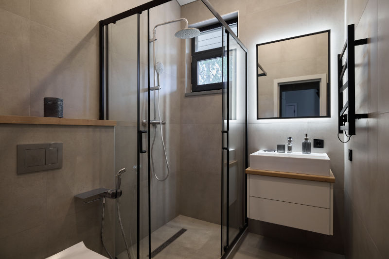 Black frame shower window above a walk-in shower in a modern bathroom design