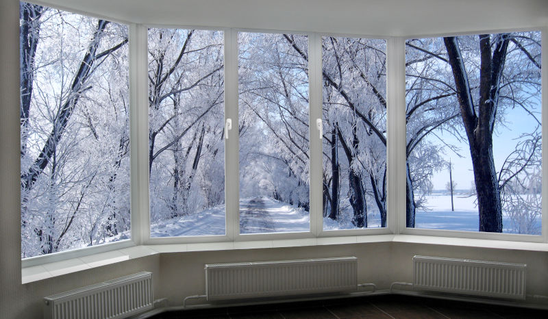 Energy-efficient bay or bow windows overlooking a snowy winter landscape with trees