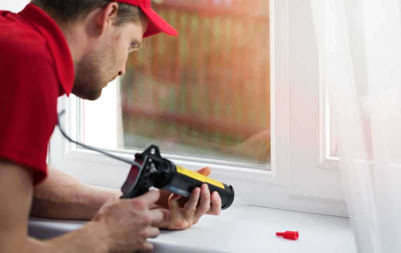 Home improvement professional sealing interior window trim with paintable caulk
