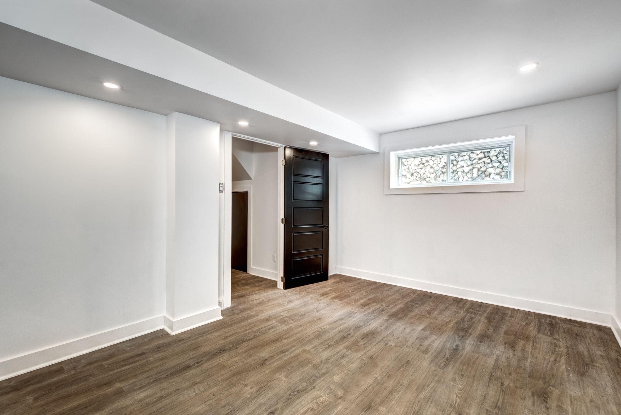 Finished basement with a newly installed replacement window, highlighting the value of professional installation for energy efficiency, safety, and long-term performance.